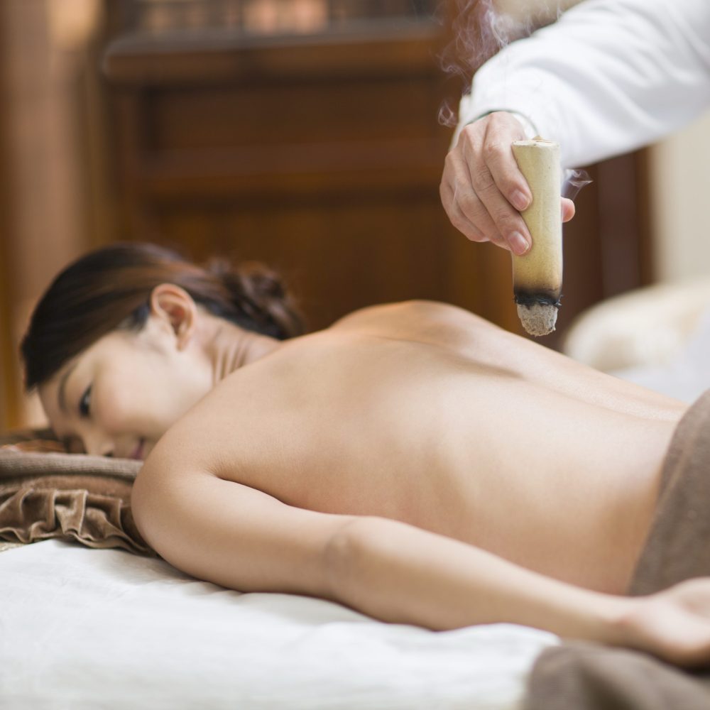 Senior Chinese doctor giving moxibustion